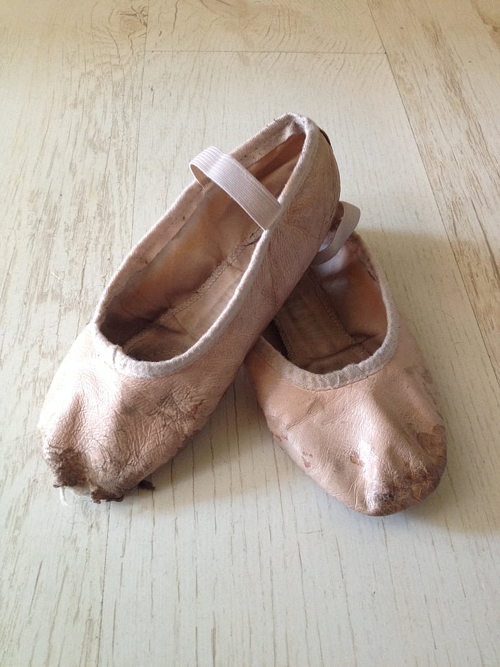 pair of pink leather ballet flats on wooden surface