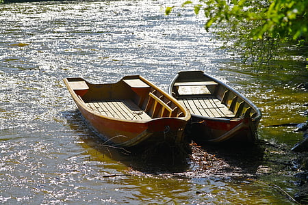 two gray and brown boats near green leafed tree