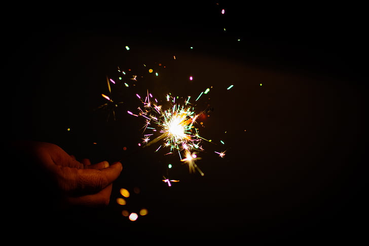 person holdiing multicolored sparkler