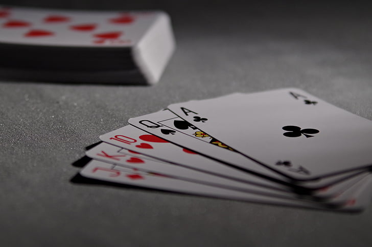 selective focus photography of playing cards on gray textile