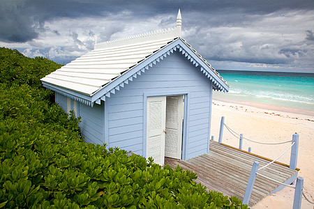 blue wooden house near ocean water