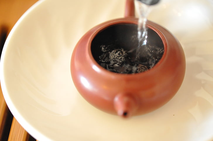 water poured in brown teapot