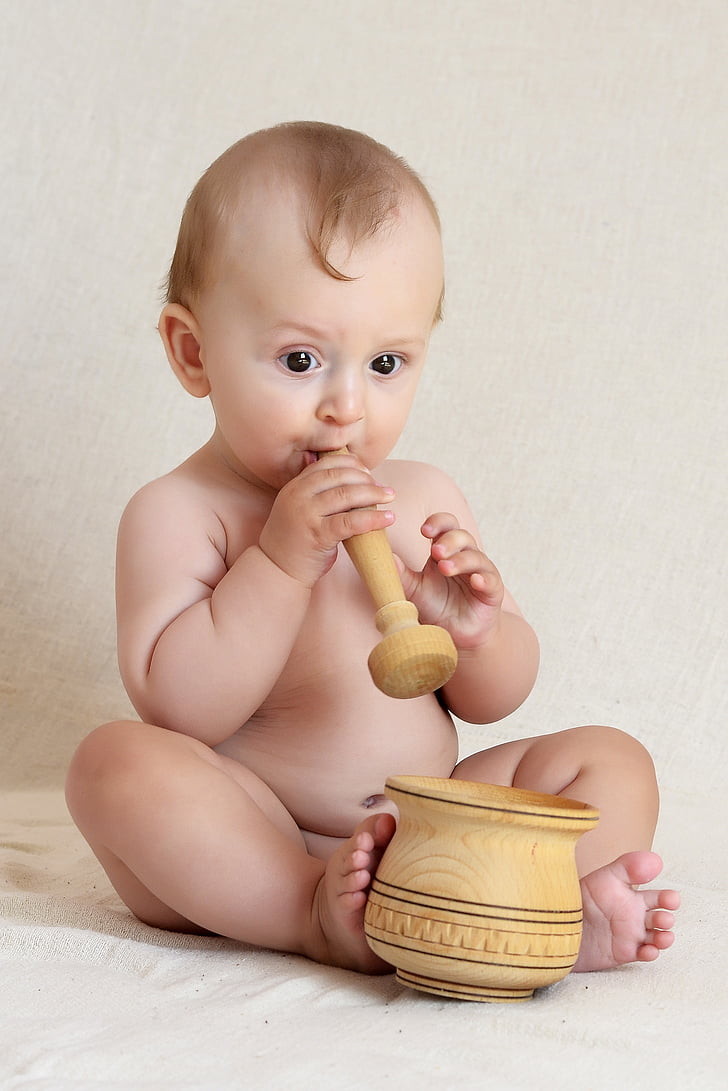 baby boy holding mortar and pestle