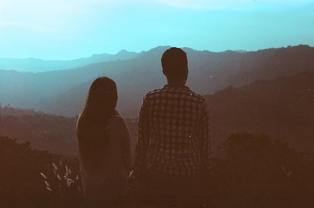 man and woman standing in front of mountain