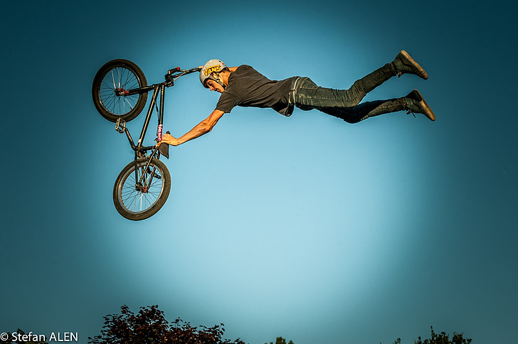 man holding BMX bike making stunt