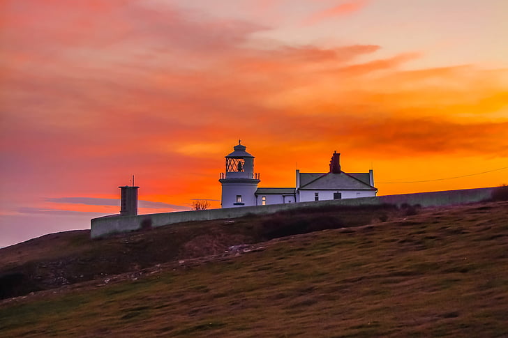 lighthouse under sunset sky