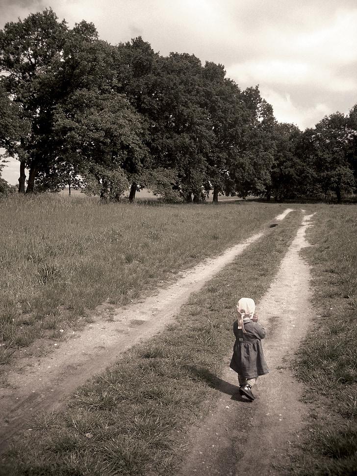 child walking toward forest