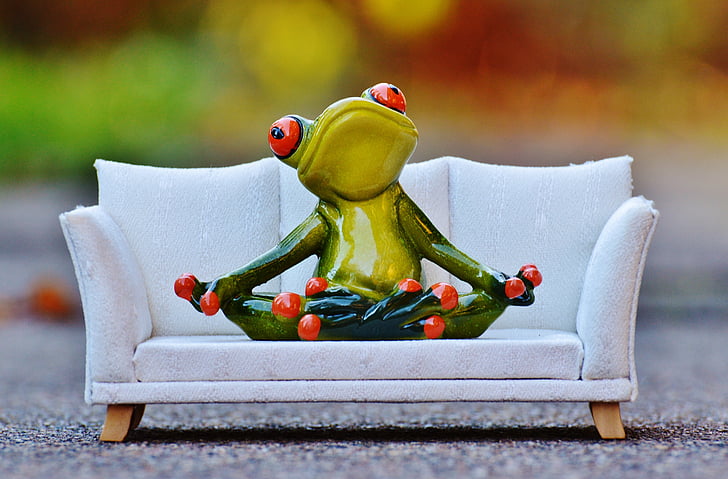 Royalty-Free photo: Green and red ceramic frog figurine on white