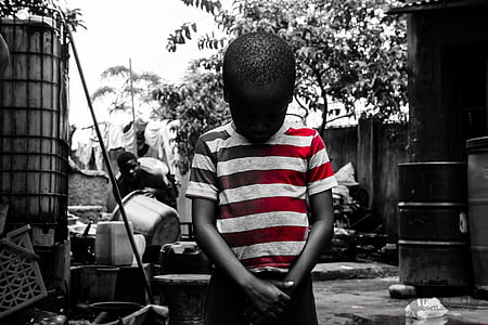 selective color photography of boy wearing stripe shirt looking down