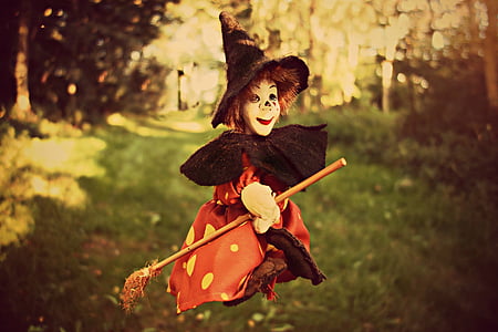 child with witch costume riding broomstick during daytime