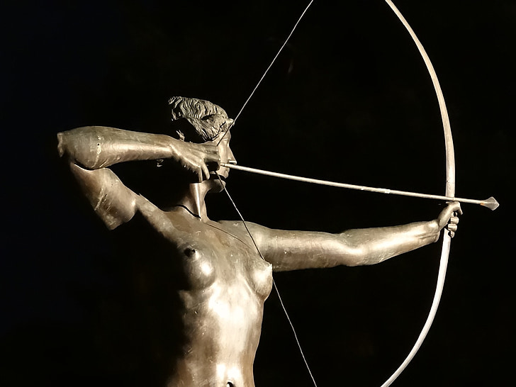 person holding bow and arrow statue