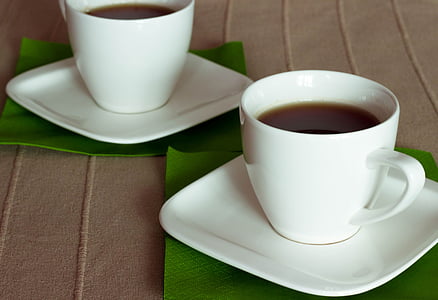 two cups of coffee placed on brown sheet