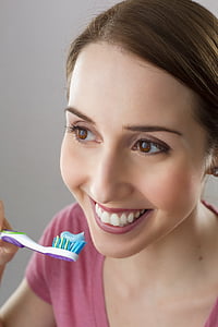 woman holding toothbrush while smiling