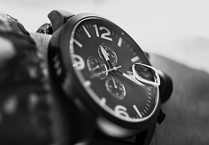 close up photograph of person wearing round bezel chronograph watch