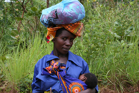 woman wearing blue dress breastfeeding baby