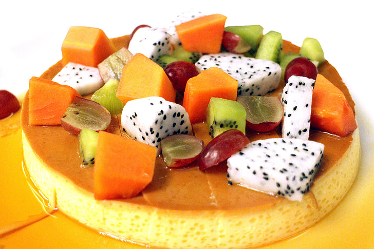 sliced kiwi, papaya, grape, and dragon fruit topped caramel flan