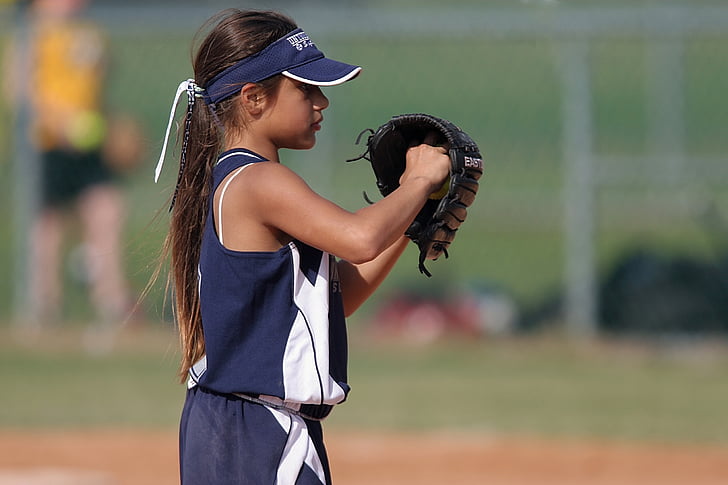 girl playing baseball on field