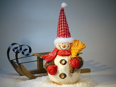 Snowman wooden figurine beside sled