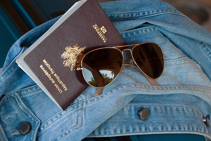 gold framed aviator-style sunglasses and passport