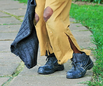 person wearing distressed yellow pants and black boots