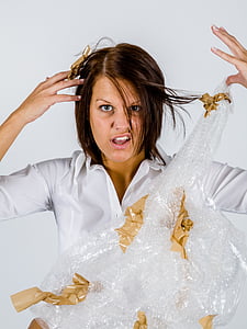 woman in white top holding bubble wrap