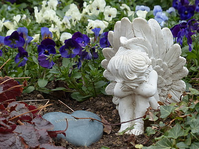 white ceramic angel statuette near purple and white flowers