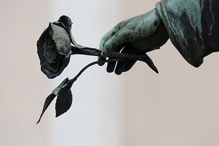 human hand holding rose statue