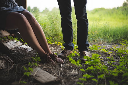 man wearing brown tassel shoes beside woman in brown sneakers near green grass open field
