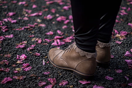 photo of person wearing brown suede shoes between pink flower petals