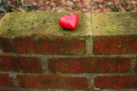 red heart figurine on brown brick