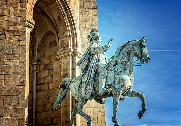 man riding on a horse statue during daytime