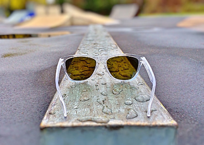clear plastic framed sunglasses on brown wooden board