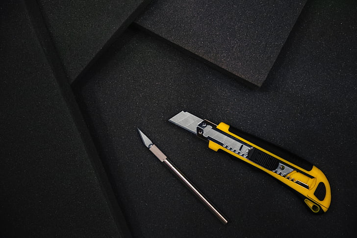 yellow utility knife on black mat