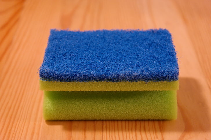 blue and yellow sponge on brown wooden surface
