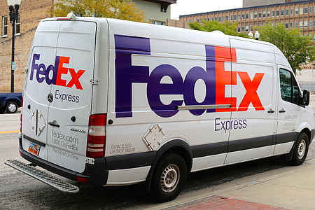 white FedEx delivery van parked on roadside near building at daytime