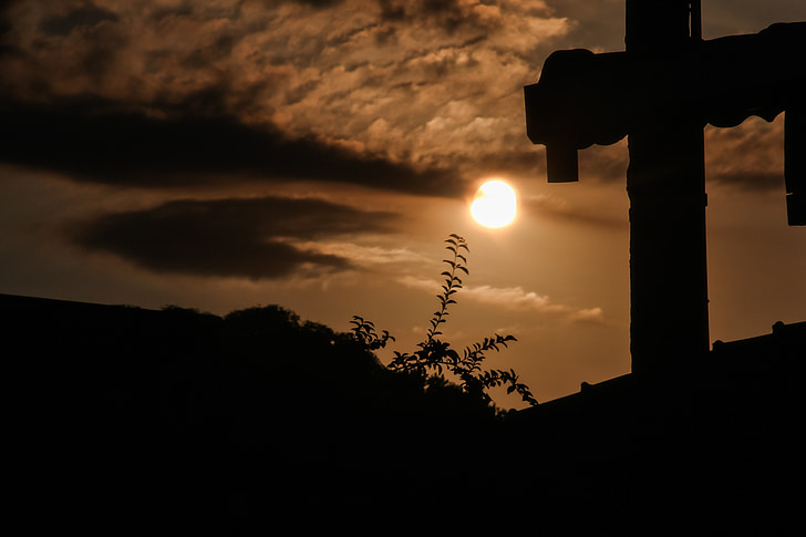 silhouette of cross on top of roof