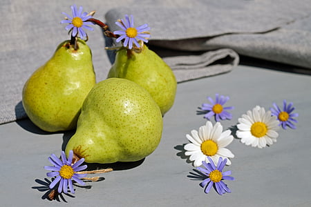 three yellow fruits and white and purple petaled flowers at daytime