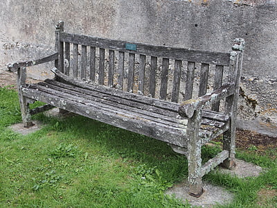 gray wooden bench beside wall