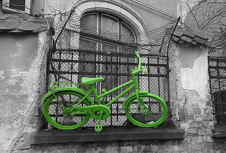 green commuter bicycle stuck on fence