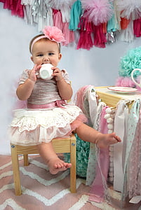 girl wearing pink and white tutu dress having a tea motif photo shoot