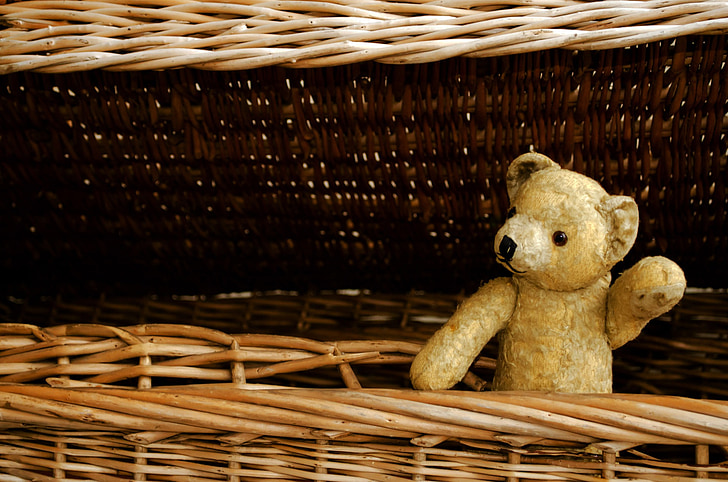beige bear plush toy on brown wicker basket