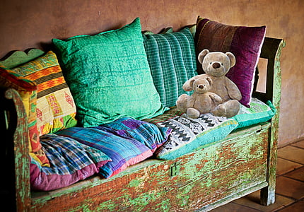 assorted-color throw pillows and two brown bear plush toys