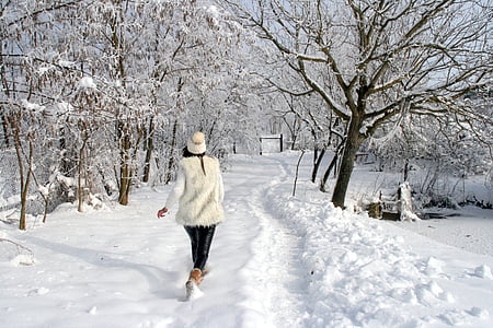 woman walking on snowfield during daytime