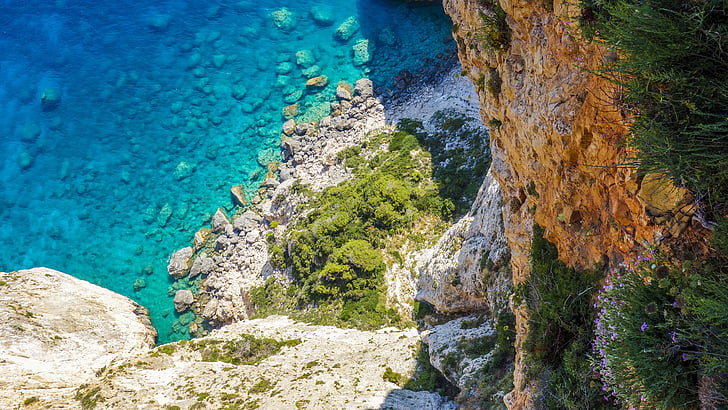 high angle photography of cliff near body of water