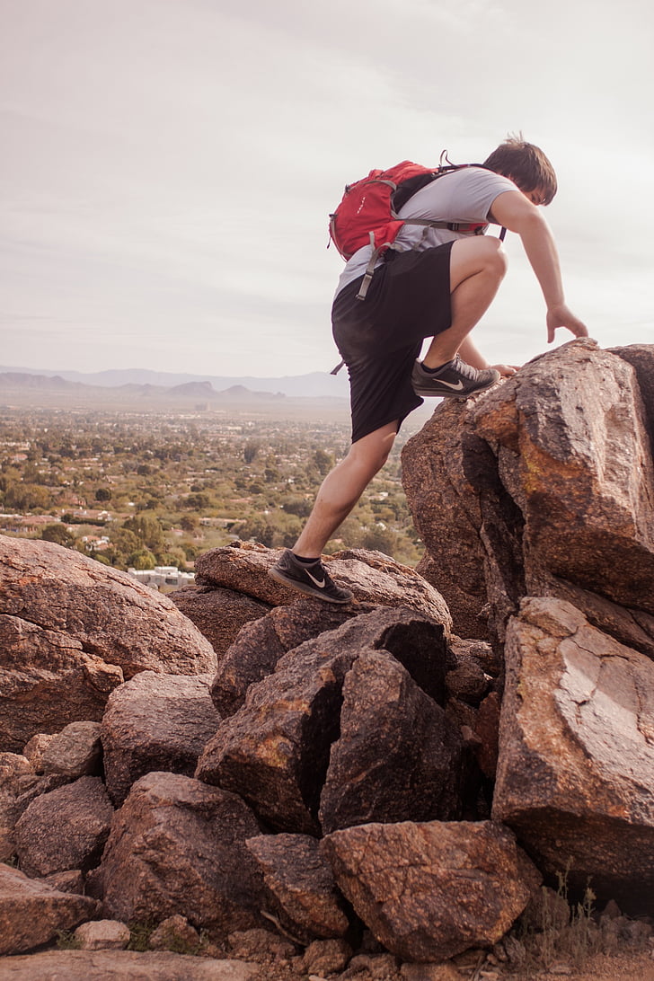 man climbing rock formation