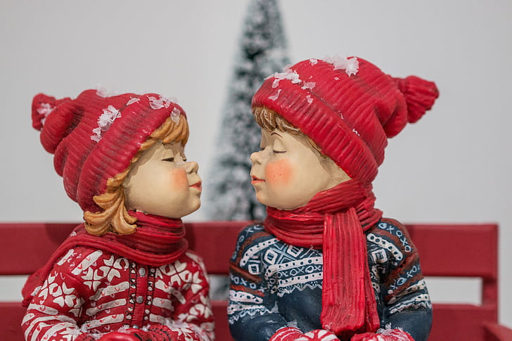 boy and girl wearing hat facing each other figurine