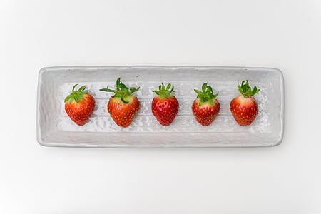 photo of five strawberries with case