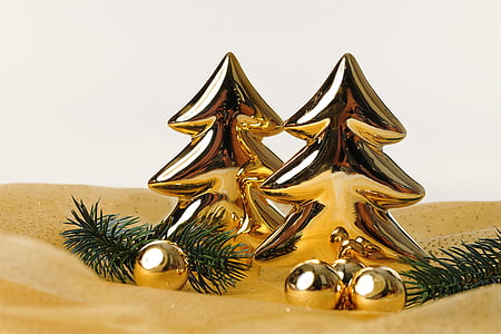 two gold-colored Christmas tree decors on sand