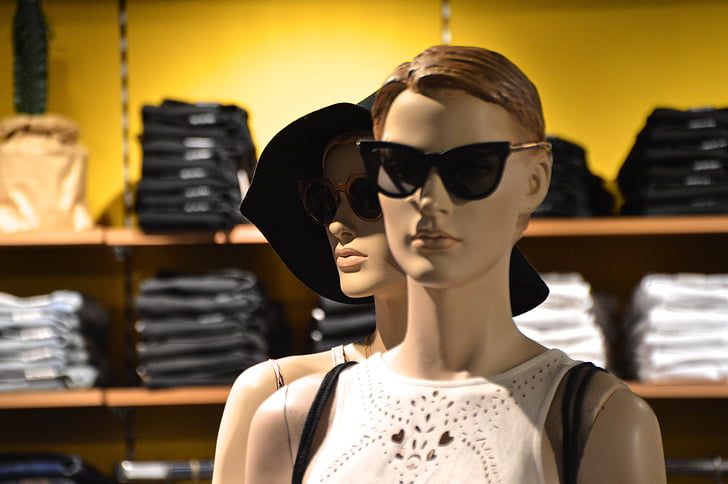 two woman mannequin wearing white sleeveless shirt in room