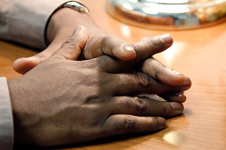 person's hand on brown wooden table